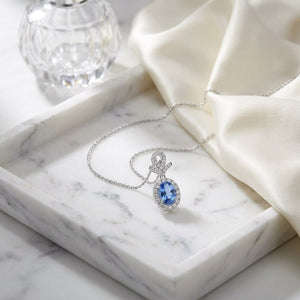 Sapphire Oval Halo Pendant in 14K White Gold, on marble vanity tray with silk