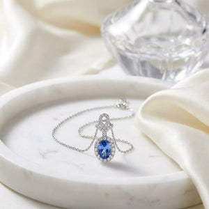 Tanzanite Oval Halo Pendant in 14K White Gold, on marble vanity tray with silk