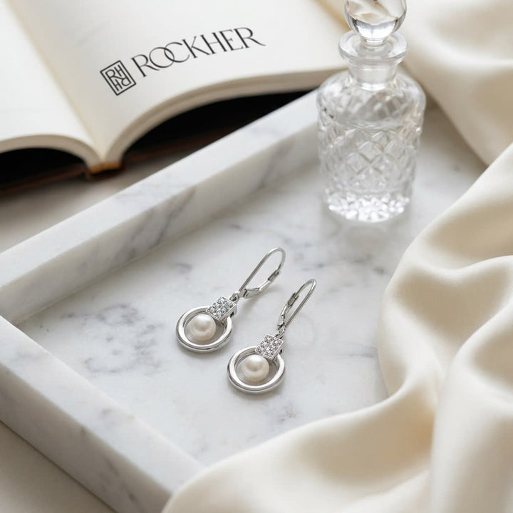 Pearl And Diamond Drop Earrings in 14K White Gold, on marble vanity tray with silk