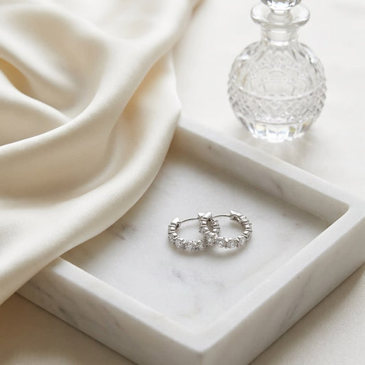 Diamond Hinged Oval Hoop Earrings in 14k White Gold 0.70ctw, on marble vanity tray with silk