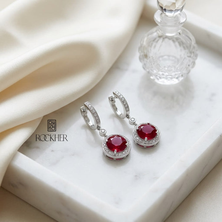 Ruby And Diamond Earrings in 14K White Gold, on marble vanity tray with silk