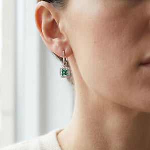 Created Emerald And Diamond Dangle Clover Leverback Earrings in 14K White Gold, worn close-up portrait
