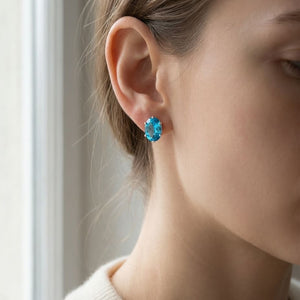 Swiss Blue Topaz Oval Stud Earrings in 14K White Gold, worn close-up portrait