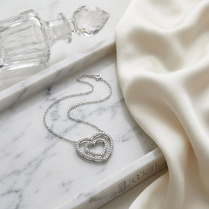 Diamond Double Heart Frame Necklace in 14K White Gold, on marble vanity tray with silk