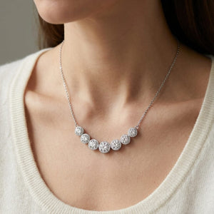Diamond 7-stone Round Bezel Graduated Necklace With Millgrained Edging in 14K White Gold, worn close-up portrait