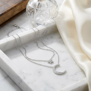 Diamond Star And Moon Layered Necklace in 14K White Gold, 16-18 Inch Adj Chain, on marble vanity tray with silk
