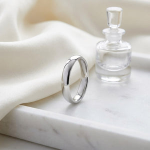 4mm Slightly Domed Comfort-Fit Wedding Band in 14K White Gold, on marble vanity tray with silk