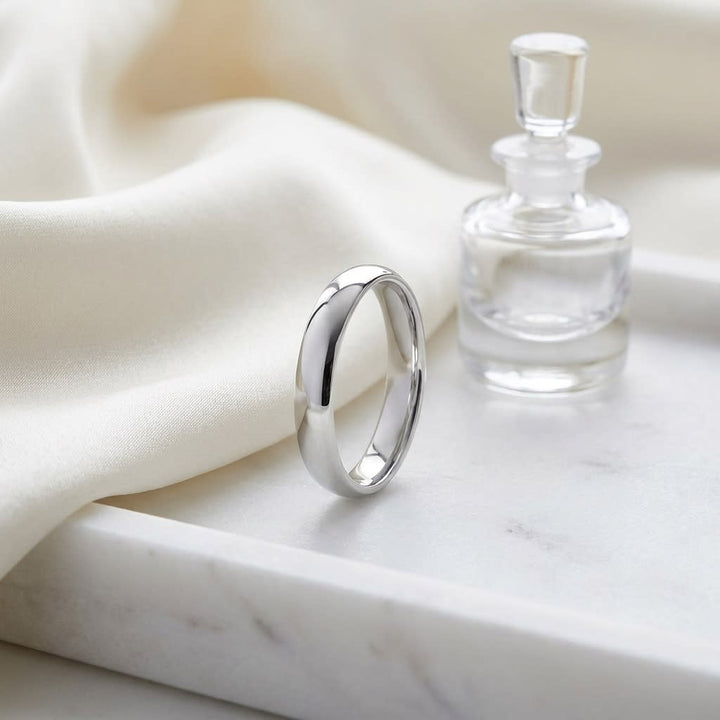 4mm Slightly Domed Comfort-Fit Wedding Band in 14K White Gold, on marble vanity tray with silk