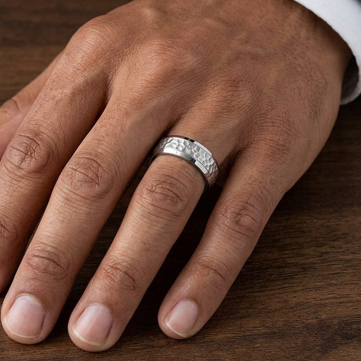 7.5mm Hammered Finish Beveled Edge Carved Wedding Band in 14K White Gold, worn on hand, masculine close-up