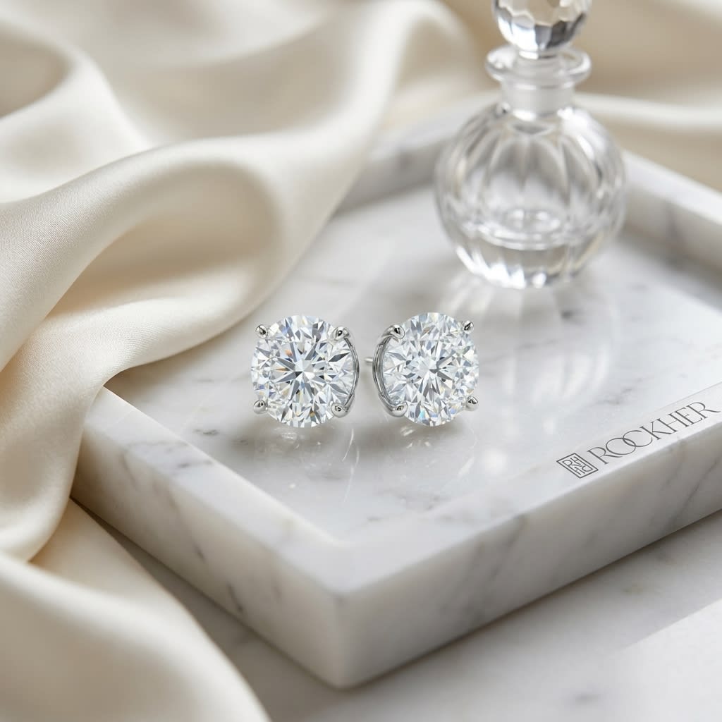 4-Prong Lab Diamond Stud Earrings | Round Brilliant, DEF VS Ideal Cut, IGI Certified, on marble vanity tray with silk