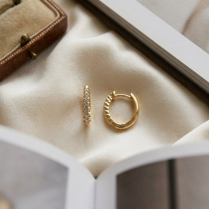 Diamond Oval Hoop Huggie Earrings 1/4ctw in 14K Yellow Gold - flat lay