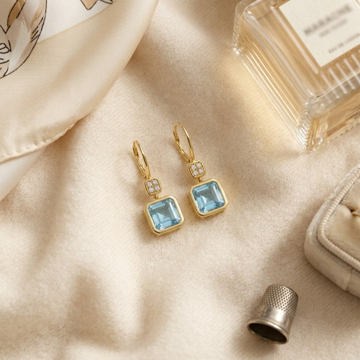 Swiss Blue Topaz Bezel Earrings 0.08ctw in 14K Yellow Gold - flat lay