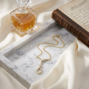 Open Kite Diamond Drop Necklace in 14K Yellow Gold, on marble vanity tray with silk