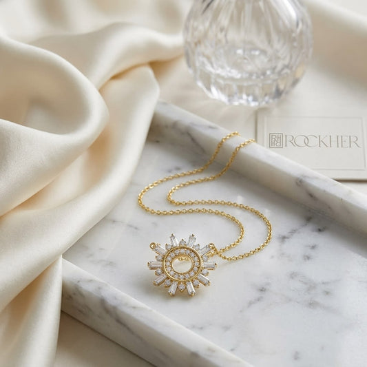 Diamond Round And Straight Baguette Starburst Necklace in 14K Yellow Gold, on marble vanity tray with silk