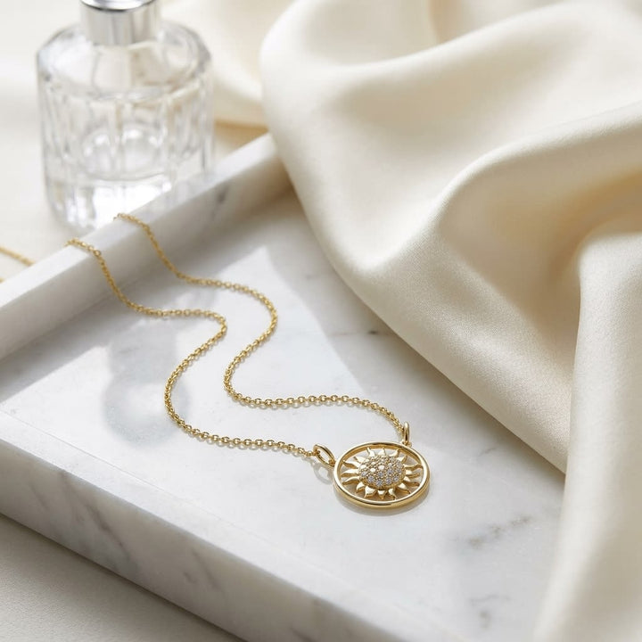 Diamond Sun Necklace With Round Frame in 14K Yellow Gold, on marble vanity tray with silk