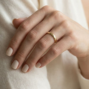 3mm Slightly Domed Traditional Oval Wedding Band in 14K Yellow Gold, worn on hand, close-up
