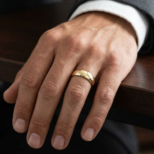 6mm Slightly Domed Traditional Oval Wedding Band in 14K Yellow Gold, worn on hand, masculine close-up