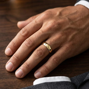 8mm Slightly Domed Traditional Oval Wedding Band in 14K Yellow Gold, worn on hand, masculine close-up