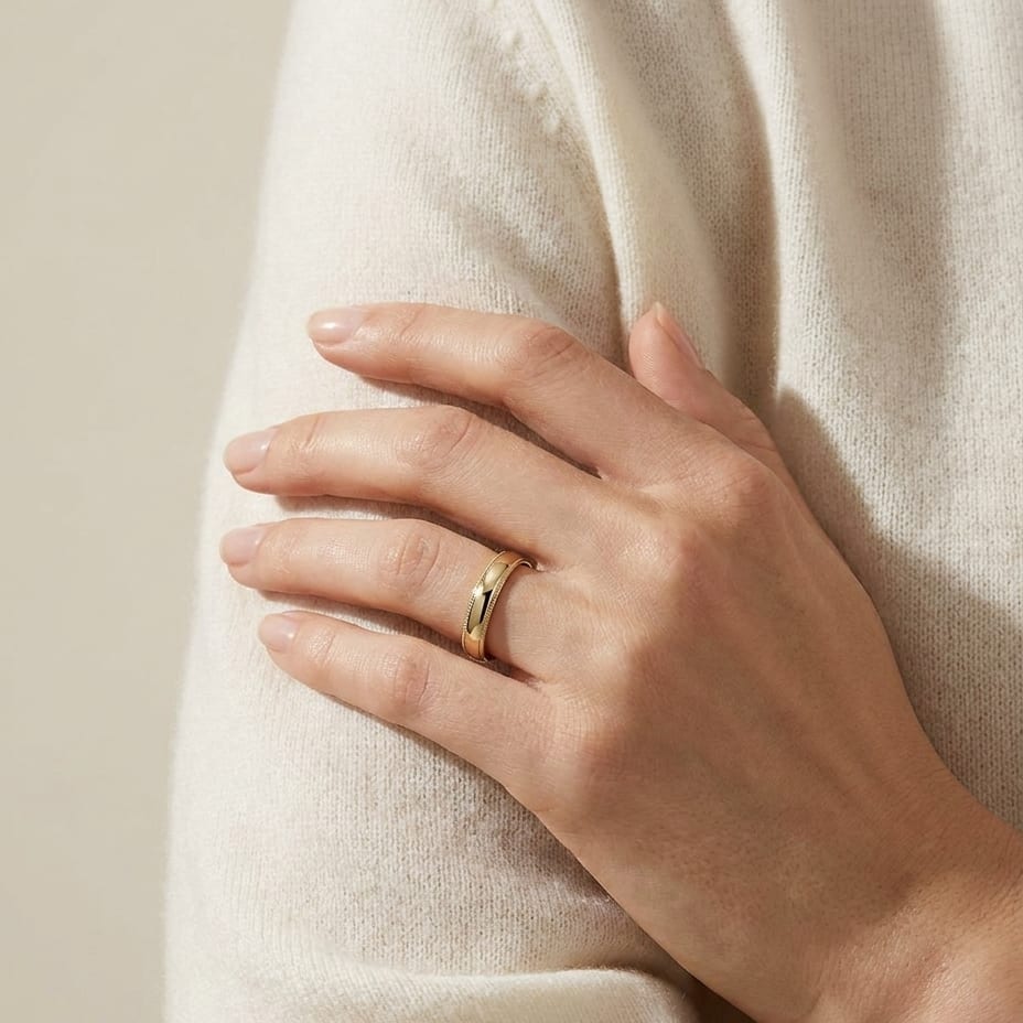 4mm Slightly Domed Traditional Oval Milgrain Wedding Band in 14K Yellow Gold, worn on hand, full view