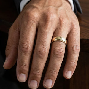 5mm Slightly Domed Traditional Oval Milgrain Wedding Band in 14K Yellow Gold, worn on hand, masculine close-up