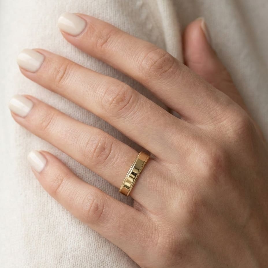4mm Flat Milgrain Comfort-Fit Wedding Band in 14K Yellow Gold, worn on hand, close-up