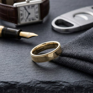 6mm Flat Milgrain Comfort-Fit Wedding Band in 14K Yellow Gold, on walnut surface with pocket square