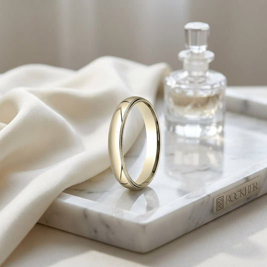 4mm Slightly Domed Milgrain Comfort-Fit Wedding Band in 14K Yellow Gold, on marble vanity tray with silk