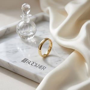 4mm Slightly Domed Super Light Comfort-Fit Wedding Band in 14K Yellow Gold, on marble vanity tray with silk