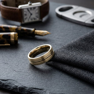 6mm Satin Finish High Polished Center Cut Carved Wedding Band in 14K Yellow Gold, on walnut surface with pocket square