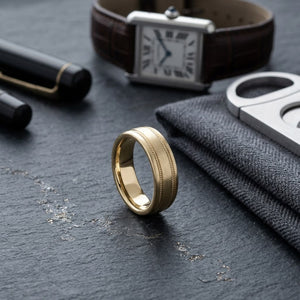 7.5mm Satin Finish Rope Carved Wedding Band in 14K Yellow Gold, on walnut surface with pocket square