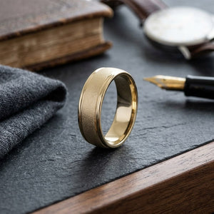7mm Wired Finish High Polished Round Edge Carved Wedding Band in 14K Yellow Gold, on walnut surface with pocket square