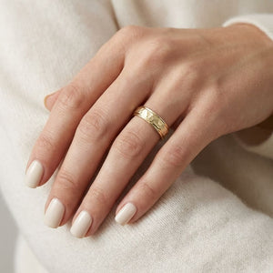 4mm Hammered Finish Carved Wedding Band in 14K Yellow Gold, worn on hand, close-up