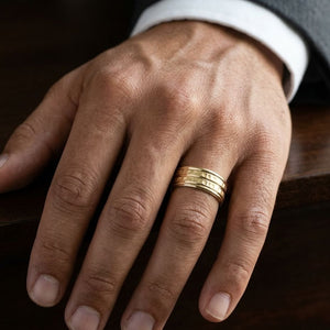 7.5mm High Polish Round Edge Carved Wedding Band in 14K Yellow Gold, worn on hand, masculine close-up