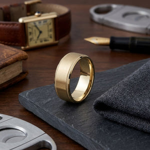 8mm Satin Finish Carved Wedding Band in 14K Yellow Gold, on walnut surface with pocket square