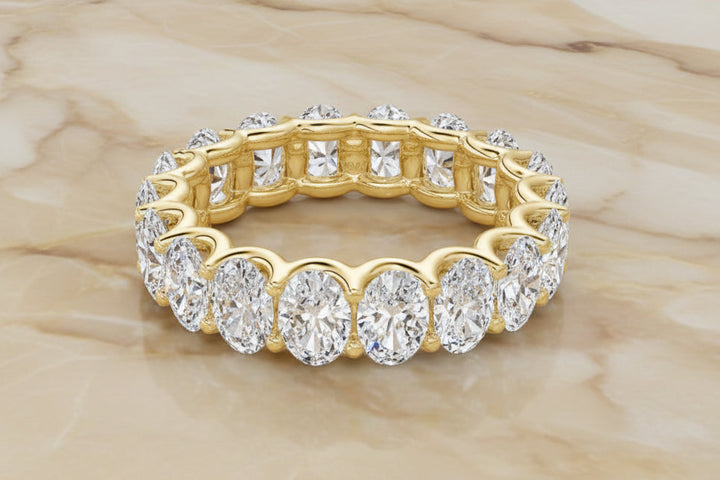 Oval cut natural diamond eternity band in 14K yellow gold — front
