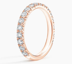 A rose gold eternity ring featuring a continuous row of round-cut clear gemstones in a prong setting, shown on a clean white background.