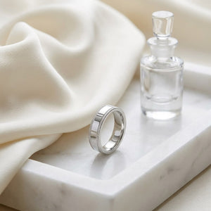 4mm Flat Milgrain Comfort-Fit Wedding Band in Platinum, on marble vanity tray with silk
