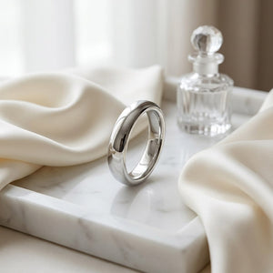 4mm High Dome Comfort-Fit Wedding Band in Platinum, on marble vanity tray with silk