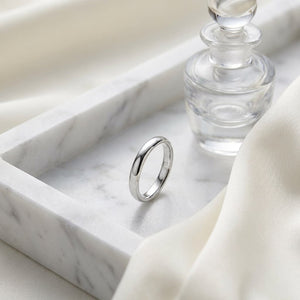 2.5mm Slightly Domed Comfort-Fit Wedding Band in Platinum, on marble vanity tray with silk