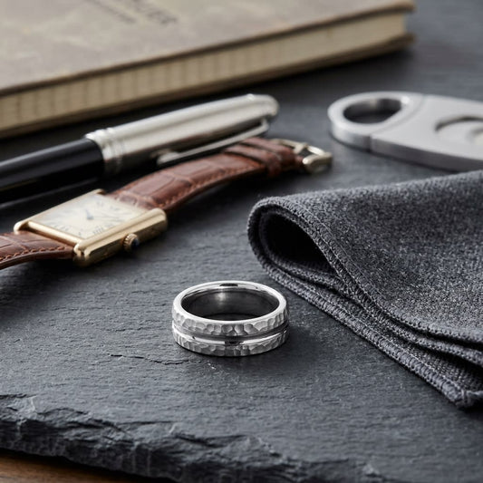 7.5mm Hammered Finish Carved Wedding Band in Platinum, on walnut surface with pocket square