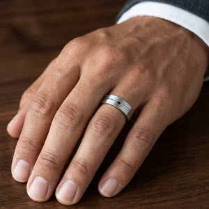 6mm Satin Finish High Polished Center Cut Carved Wedding Band in Platinum, worn on hand, masculine close-up