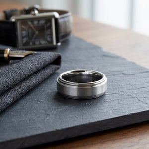 8mm Satin Finish Carved Wedding Band in Platinum, on walnut surface with pocket square