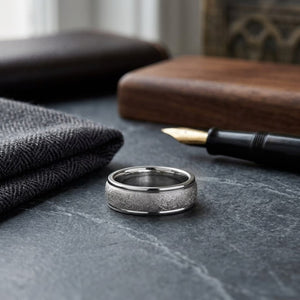 6.5mm Round Edge Swirl Finish Carved Wedding Band in Platinum, on walnut surface with pocket square