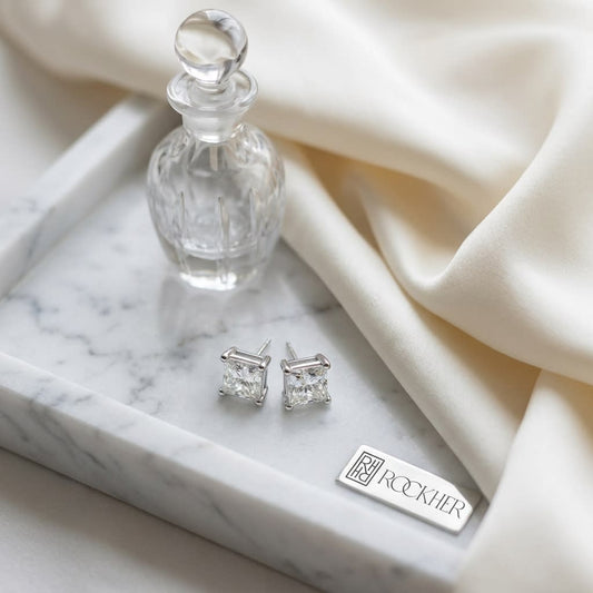 Natural Diamond Princess Cut Four Prong Stud Earrings in Platinum, 1/4 ct. t.w., on marble vanity tray with silk