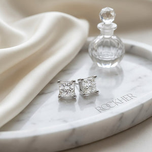 Natural Diamond Princess Cut Four Prong Stud Earrings in Platinum, 1/3 ct. t.w., on marble vanity tray with silk