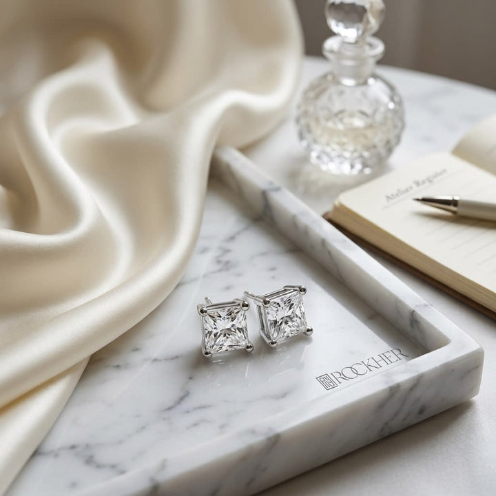 Natural Diamond Princess Cut Four Prong Stud Earrings in Platinum, 1/3 ct. t.w., on marble vanity tray with silk