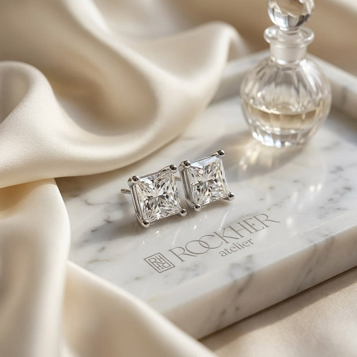 Natural Diamond Princess Cut Four Prong Stud Earrings in Platinum, 1/2 ct. t.w., on marble vanity tray with silk