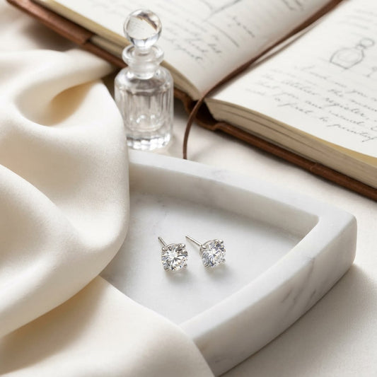 Platinum 4-prong Round Brilliant Diamond Stud Earrings (0.75 Ct. T.w., Vs1-vs2 Clarity, H-i Color), on marble vanity tray with silk