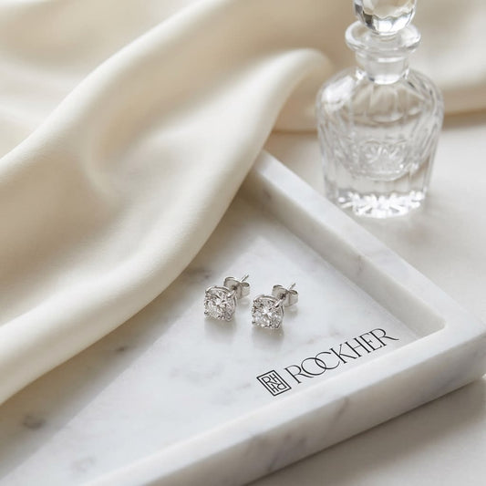 Natural Diamond Round Brilliant Bezel Stud Earrings in Platinum, 2 ct. t.w., on marble vanity tray with silk