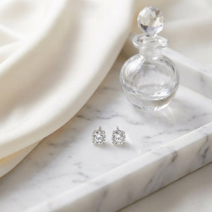 Platinum Bezel Set Round Brilliant Diamond Stud Earrings (1 Ct. T.w., Si1-si2 Clarity, H-i Color), on marble vanity tray with silk